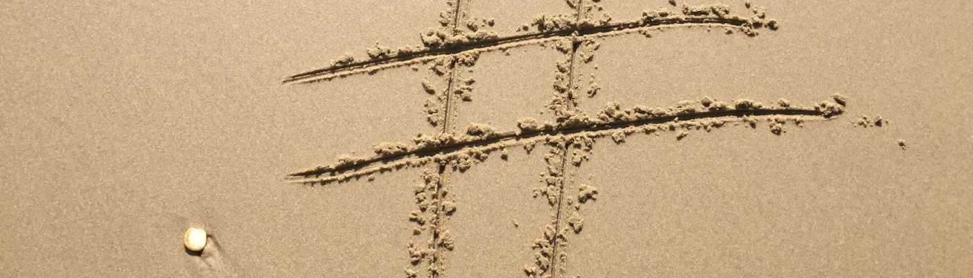 Hashtag symbol drawn into sand on beach