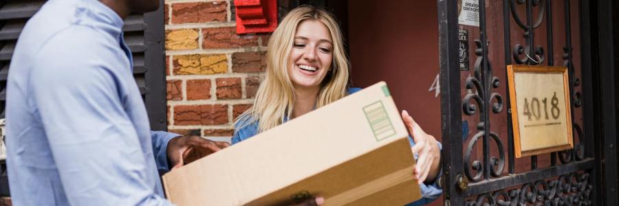 Smiling woman receiving package from courier