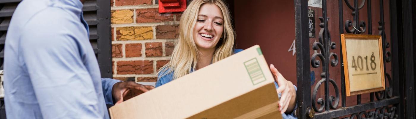 Smiling woman receiving package from courier
