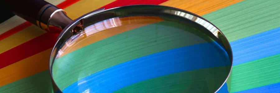 Magnifying glass on top of colorful paper