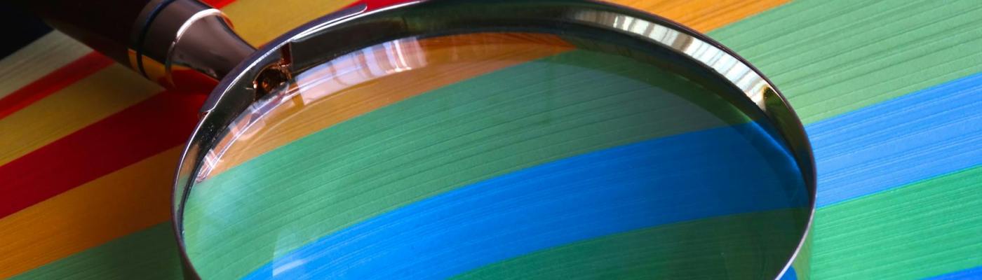 Magnifying glass on top of colorful paper