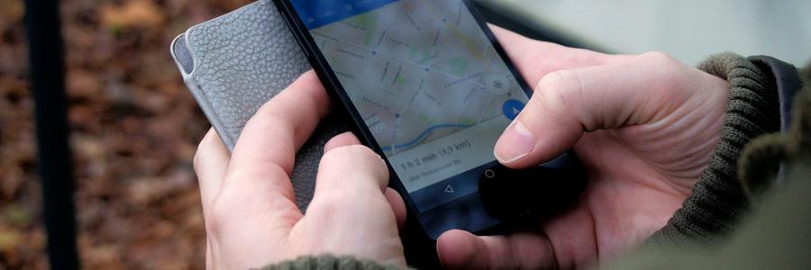 Person using Google Maps app on black smartphone