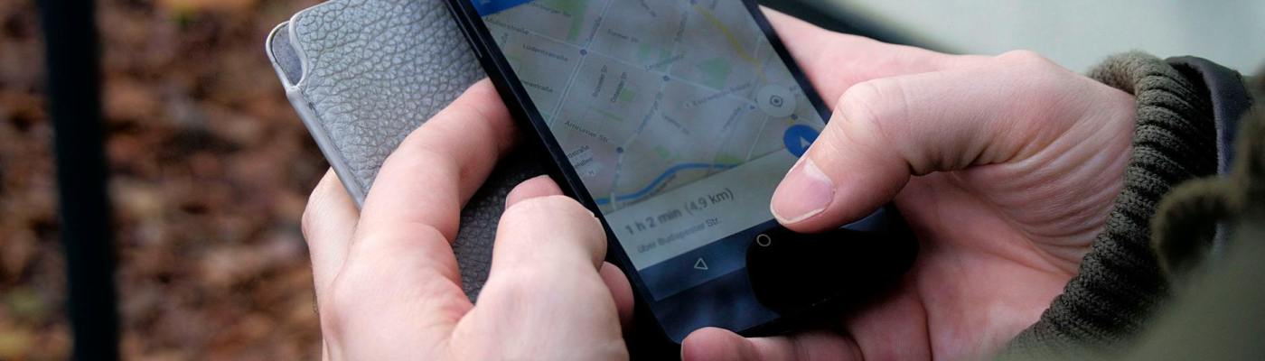 Person using Google Maps app on black smartphone